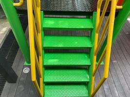 children staircase. green and yellow steel staircase with iron hand railing and mesh. kids stairs design for playground and school. photo