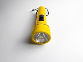 yellow flashlight on white background. copy space. flashlight for blackout and emergency. selected focus photo