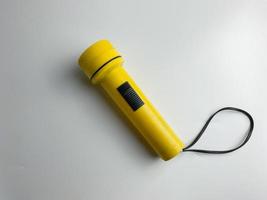 yellow flashlight on white background. copy space. flashlight for blackout and emergency. selected focus photo