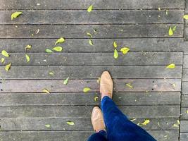 De las mujeres piernas en un sencillo marrón zapatos. parte superior ver de mujer pierna vistiendo Zapatos y flaco azul vaqueros. sencillo y calle moda. foto