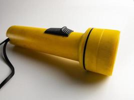 yellow flashlight on white background. copy space. flashlight for blackout and emergency. selected focus photo