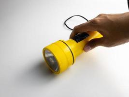 yellow flashlight on white background. copy space. flashlight for blackout and emergency. selected focus photo