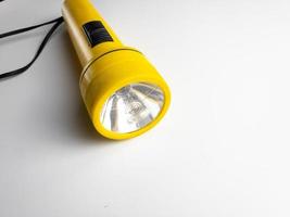 yellow flashlight on white background. copy space. flashlight for blackout and emergency. selected focus photo