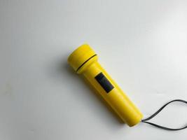 yellow flashlight on white background. copy space. flashlight for blackout and emergency. selected focus photo