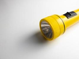 yellow flashlight on white background. copy space. flashlight for blackout and emergency. selected focus photo