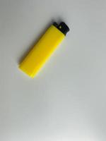 yellow lighter isolated on white background. hand tried to lit yellow lighter. copy space. selected focus photo