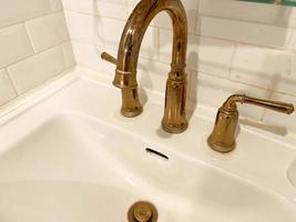 Interior of bathroom with retro classic washbasin and gold faucet. Bathroom interior sink with classic design in luxury hotel. photo