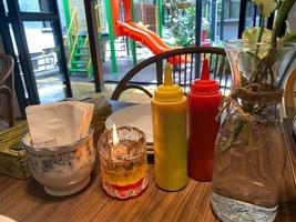 condiment at restaurant. tissue, candle, and sauces essential at the table restaurant photo