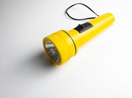 yellow flashlight on white background. copy space. flashlight for blackout and emergency. selected focus photo