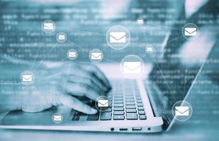 Hand using laptop with communication icons, letter icon, email icons, and newsletter email and protect your personal information or spam mail, Customer service call center contact. work from home photo