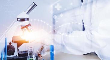 biochemical research scientist working with a microscope for the virus,Doctor man write a history of the experimental results in a , laboratory glassware containing chemical liquid for design. photo