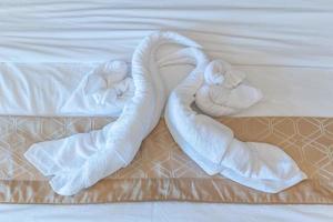 Clean white bath towels on the hotel bed photo