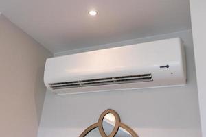 Air conditioner on white wall room interior background photo