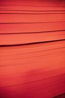 abstract background of red paper sheets, close up, vertical image photo