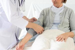 Caucasian male doctor measuring blood pressure of female patient in hospital. photo