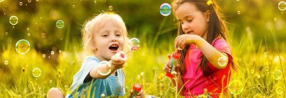 Little girls blowing soap bubbles with her grandmother outdoors photo