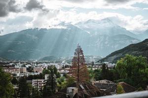 majestuoso montañas en el Alpes cubierto con arboles y nubes foto