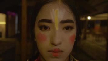 A Chinese woman looked very sad while her face looks like a clown's during the festival video