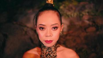 an Asian woman walking among a group of women wearing bamboo masks with smiling faces in front of the rocks video