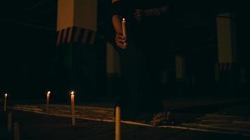 a woman in black is lighting a candle that goes out in the dark before performing a nightly devil worship video