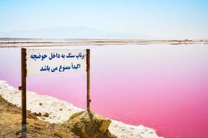 Signpost Maharlu salt lake with scenic pink salt lake panorama in sunny day. Shiraz. Iran photo