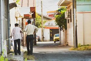 Bandar Anzali, Iran - 10th june, 2022 - muslim son help father walk in street home photo