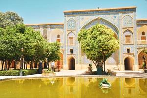 Shiraz, Iran - june 6th, 2022 - Khan school.Persian courtyard with green garden at Madrese e-Khan. The ancient religious school is a popular tourist attraction of the Middle East. photo