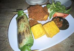 A la parrilla arroz envuelto en plátano hoja - indonesio tradicional alimento, nasi bakar foto