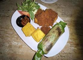 A la parrilla arroz envuelto en plátano hoja - indonesio tradicional alimento, nasi bakar foto