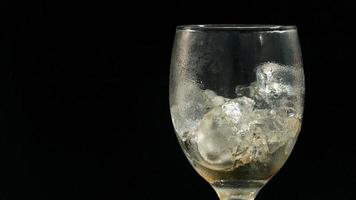 hielo es derritiendo en un claro vaso. con aislado negro antecedentes. foto