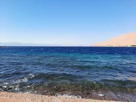 The mesmerizing view of the deep blue waters of Haql Beach in Saudi Arabia. photo