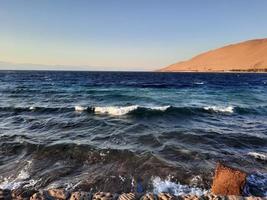 The mesmerizing view of the deep blue waters of Haql Beach in Saudi Arabia. photo