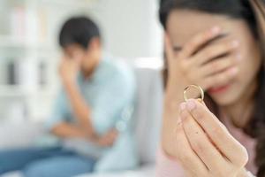 divorcio. la mujer quita el anillo casado. parejas desesperadas y decepcionadas después del matrimonio. esposo esposa triste, molesto y frustrado después de un conflicto de peleas. desconfianza, problemas de amor, traiciones, familia, amante foto