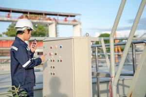 Mechanic or maintenance or electrical engineer checking main electrical control systems industrial plant. Utility fore man daily check power systems in process. Main Distribution Board, Switchboards photo