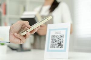 Customer use smartphones to scan QR codes to pay in-store with digital payments without cash. scanning get discounts. E wallet, technology, online payment, banking app, smart city, money transfer. photo