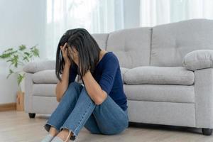 infeliz mujer asiática niña decepcionada, triste por el problema solo en casa, se siente sola, estresada, sufre de mala relación, ruptura, divorcio, mujer confundida, depresión salud mental, soledad foto