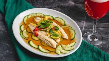 A close-up of a plate with steamed sea bream, Steamed Salmon Recipe, swirling silverfish, cucumber photo