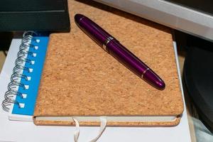 paper notebook with fountain pen on desktop photo