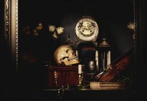 Close-up still life, Dutch painting of the 17th century. On the table on a black background are flowers, a skull, a clock, a violin, keys. Things that tell about a person's life. photo