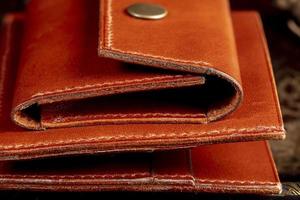 Part of a brown leather wallet or case with stitching. photo