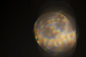 Glare effect on a black background. An abstract lens flare for on-screen use. Glare of the optical rays of the lens. photo