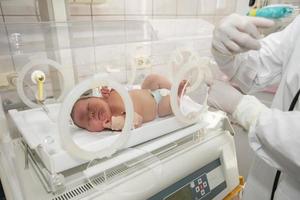 A premature newborn in a special incubator in the children's department of the hospital. photo