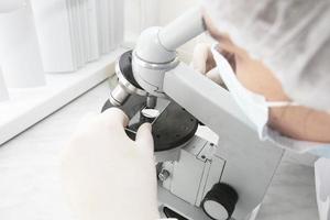 A laboratory assistant looks into a medical microscope. Research analysis. photo