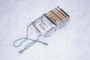 Old sled with a rope on the snow top view. photo