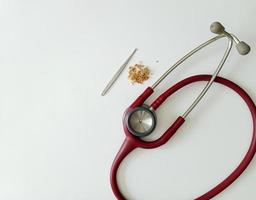 Ear wax and ear pick tools and cotton swabs with red stethoscope On the light blue table top photo