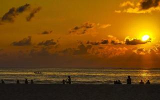 vistoso dorado puesta de sol personas ola y playa puerto escondido México. foto