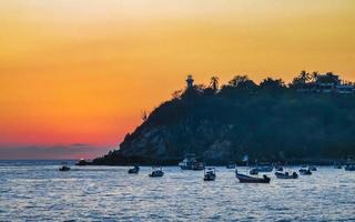 Colorful golden sunset boats wave and beach Puerto Escondido Mexico. photo