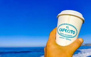 Puerto Escondido Oaxaca Mexico 2023 Coffee to go mug on the beach sand sea waves. photo