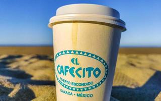 Puerto Escondido Oaxaca Mexico 2023 Coffee to go mug on the beach sand sea waves. photo