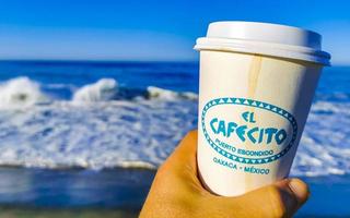 Puerto Escondido Oaxaca Mexico 2023 Coffee to go mug on the beach sand sea waves. photo